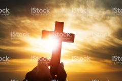 Human hand holding wooden cross.